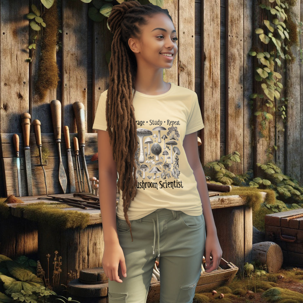 The 'Forage, Study, Repeat' Tee Shirt in butter on a model exemplifies a blend of antique scientific art, fashion, and environmental awareness, with its realistic mushroom artwork.