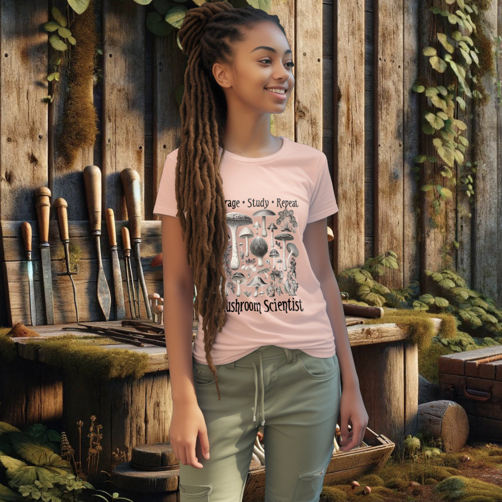Wearing the 'Forage, Study, Repeat' Tee Shirt in fraiche peche, the model presents a garment embodying the spirit of mushroom scientists, crafted for comfort and a love of fungal wonders.
