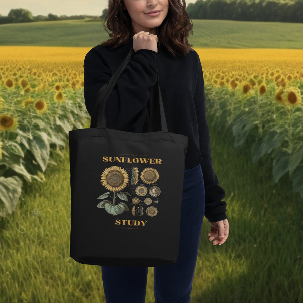 Model carrying the 'Sunflower Study' Sunflower Tote Bag in black, the botanical sunflower illustration stands out as a testament to nature's complexity, perfect for the eco-conscious art lover.