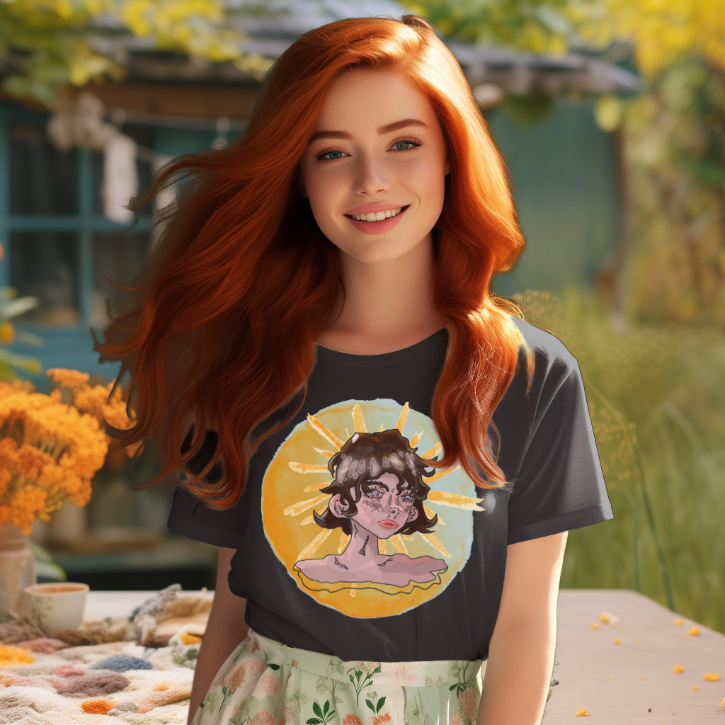 The 'Sunshine Girl' T-Shirt in anthracite worn by a model reflects a watercolor fusion of nature and human emotion, captured in the pensive gaze of the girl, wrapped in the warmth of the sun.