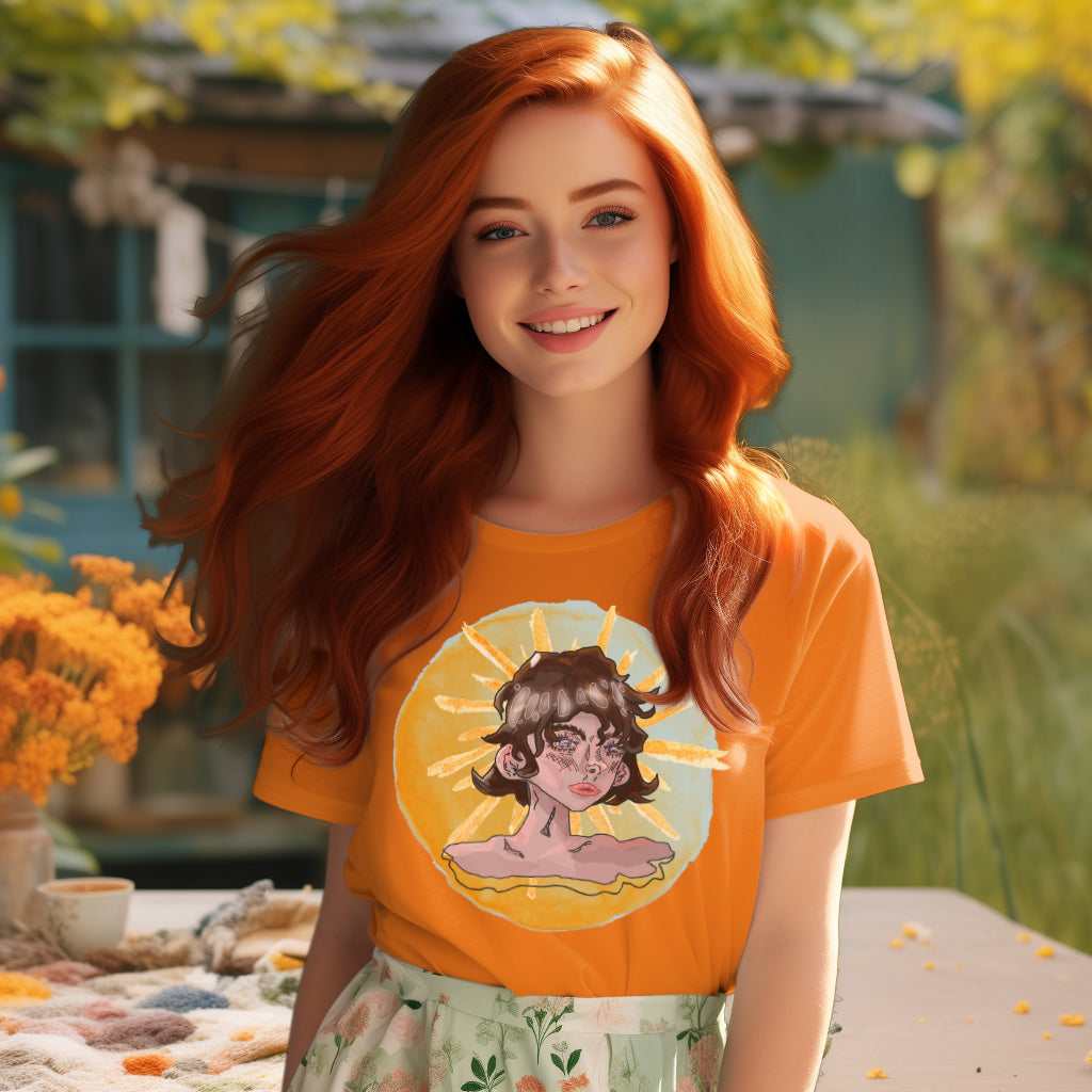 Model presenting the 'Sunshine Girl' T-Shirt in day fall orange, where the watercolor artwork of a brown-haired, blue-eyed girl conveys a world of introspection against an Art Deco sun.