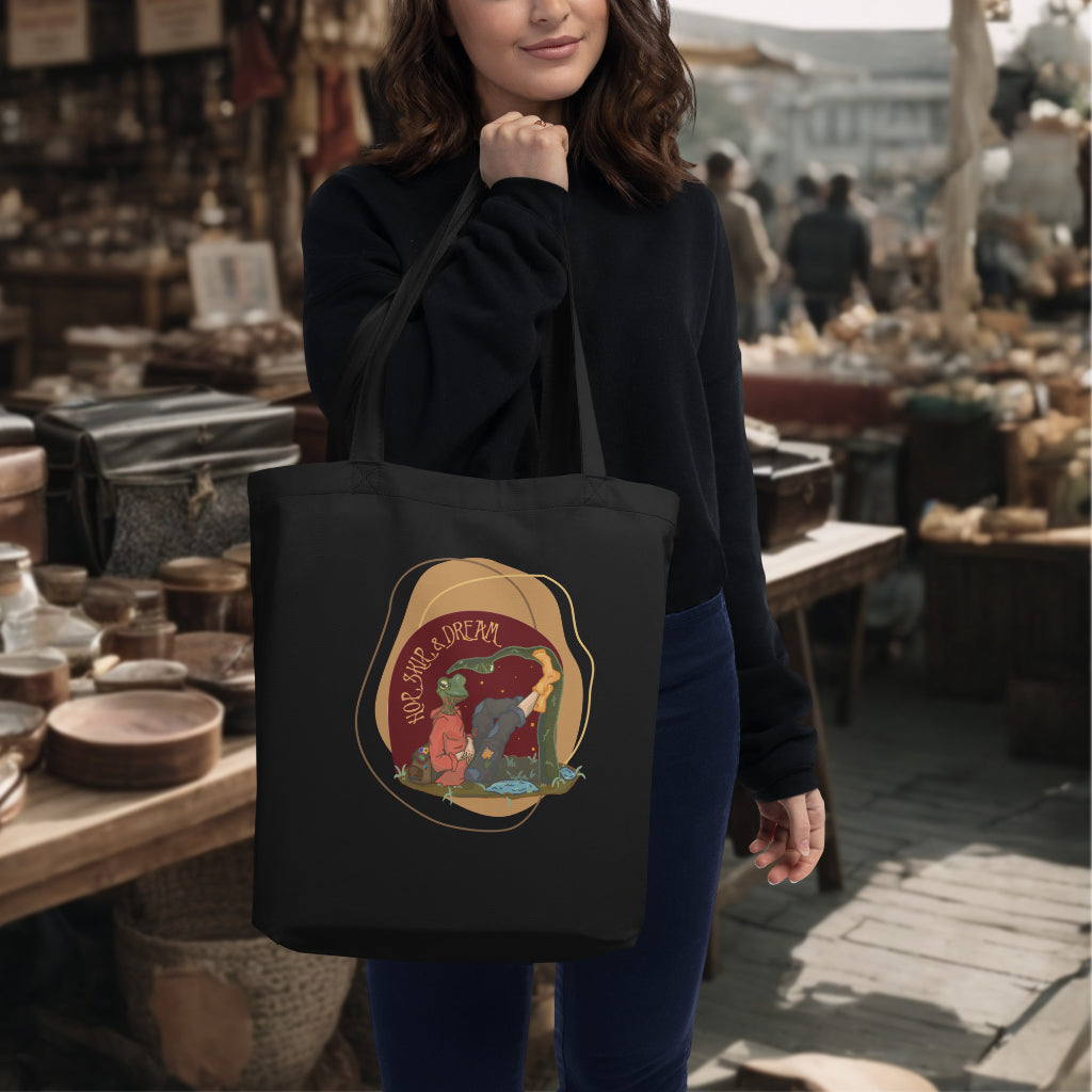 Model carrying the 'Hop, Skip Dream' Tote in black, accentuating the half frog, half human character design, a perfect blend of functionality and inspiration for the adventurous and dreamy.