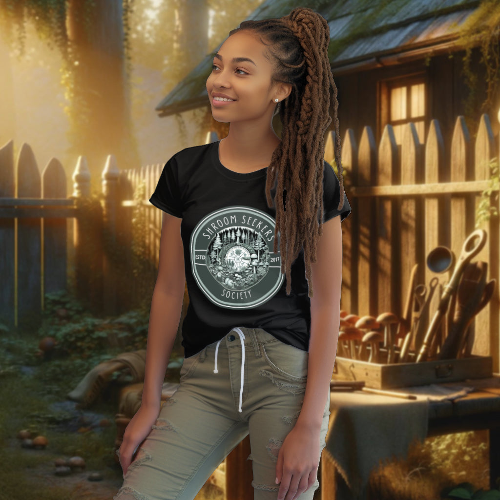 The 'Shroom Seekers Society' organic cotton black tee on a model showcases a scientific illustration of a mushroom-forest ecosystem, ideal for those passionate about mycology and sustainable fashion.