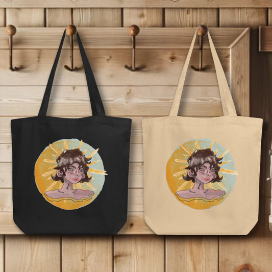 Group display of 'Sunshine Girl' Totes in black and oyster, hanging on wall hooks, each featuring the intriguing watercolor design of a contemplative girl against a sun backdrop, a blend of Art Deco inspiration and modern artistic techniques.
